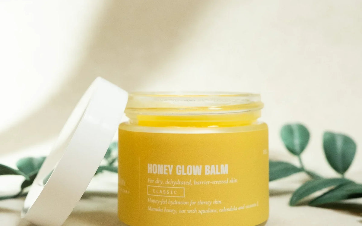 An open jar of Honey Glow whipped tallow balm with the lid beside it