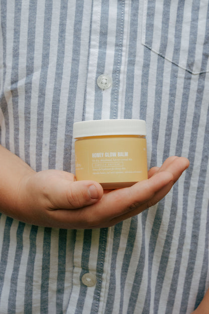 A child’s hands holding a Honey Glow jar